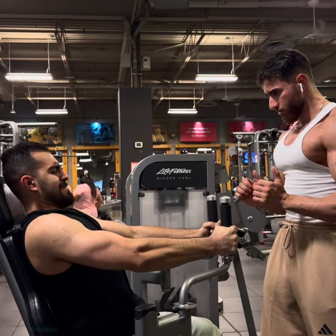 Daniel coaching a client on bicep curls