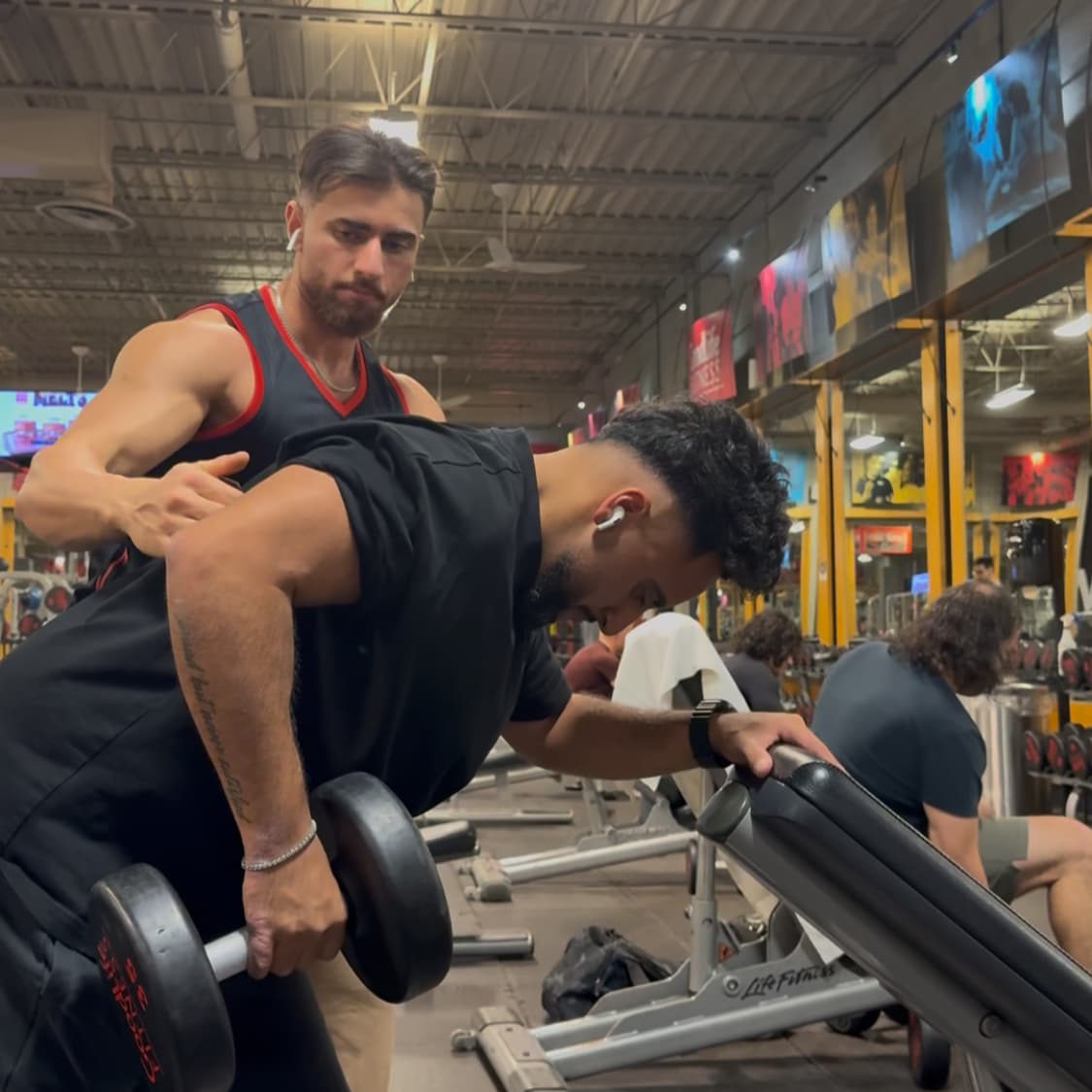 Daniel guiding a client through dumbbell rows